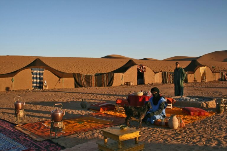 IEnjoy a magnificent seating area in a luxurious Sahara Desert Glamping camp, where warm colors harmonize with the stunning nature in the heart of the morocco road trip